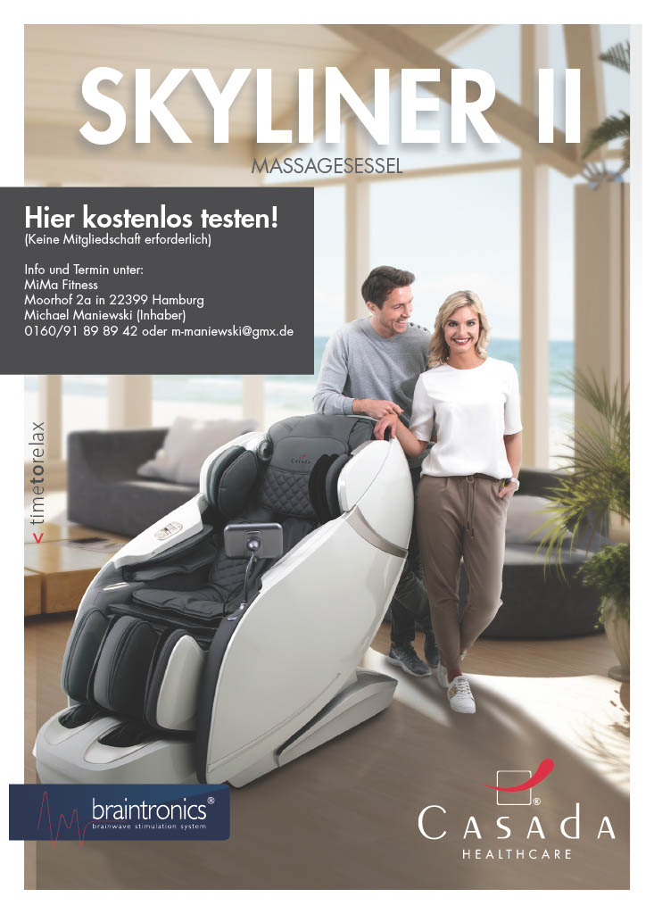 Ein Paar lächelt neben einem grauen Massagesessel, gemütliches Wohnambiente.